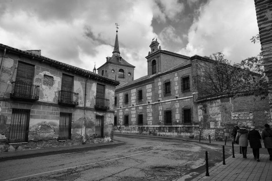 Calle empedrada en gris junto a iglesia antigua, en el chat de Azuqueca de Henares