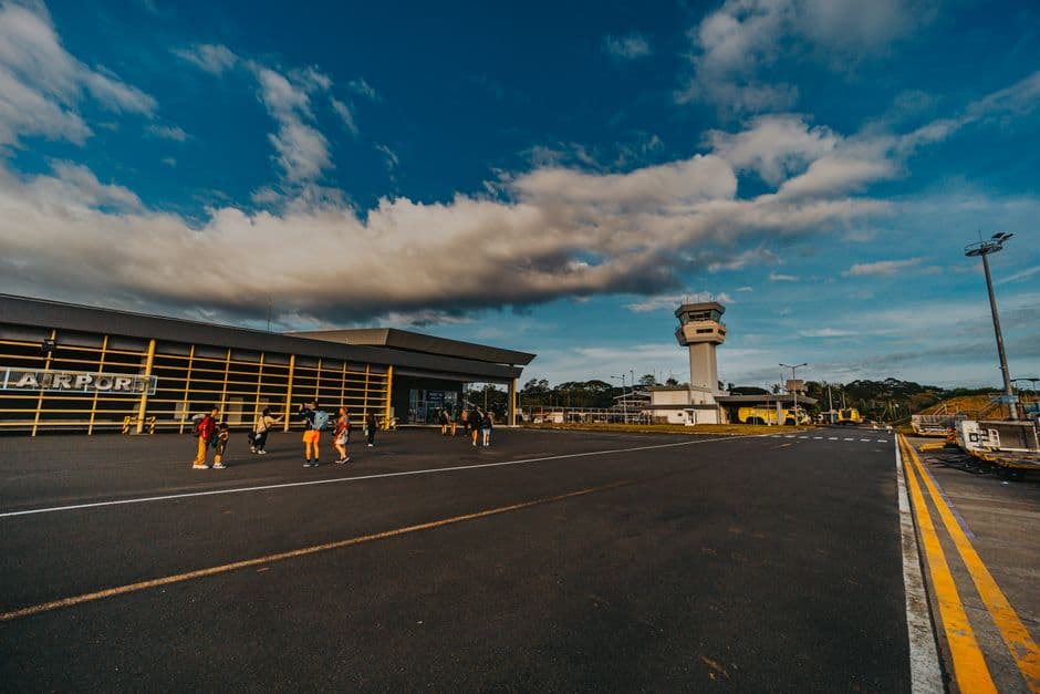 Una pequeña terminal de aeropuerto con gente fuera, en el chat de Morona Santiago