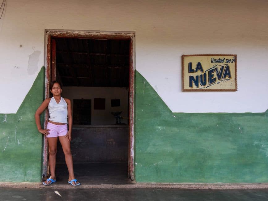 Una chica posando junto a un muro de hormigón blanco y verde, en el chat de Departamento de Nueva Segovia