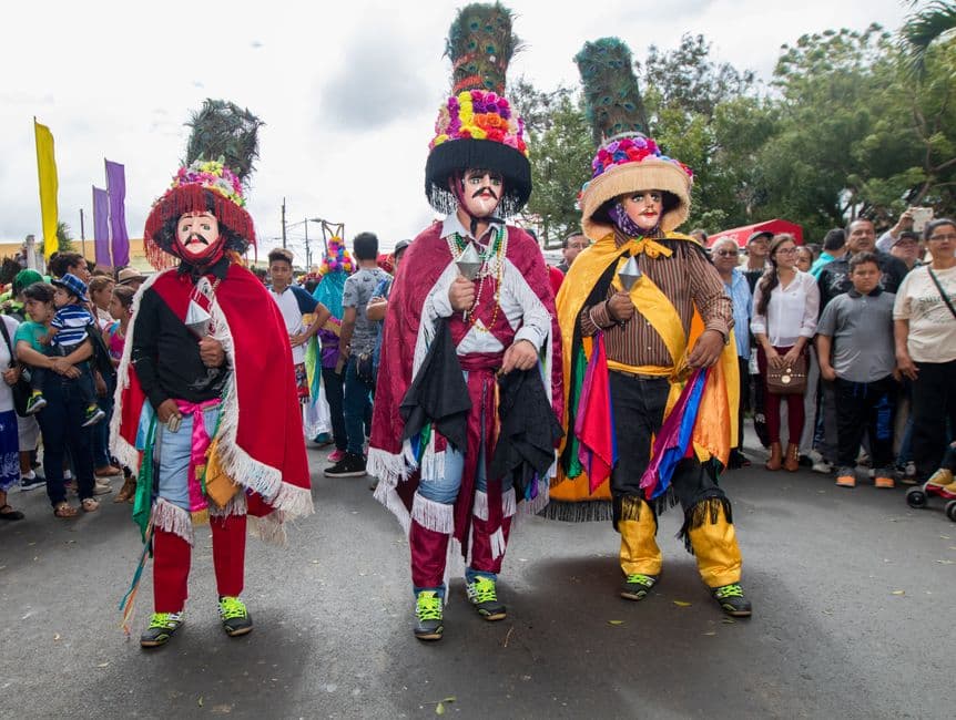 Tres hombres con el traje del Güegüense de pie en la calle, en el chat de Departamento de Carazo