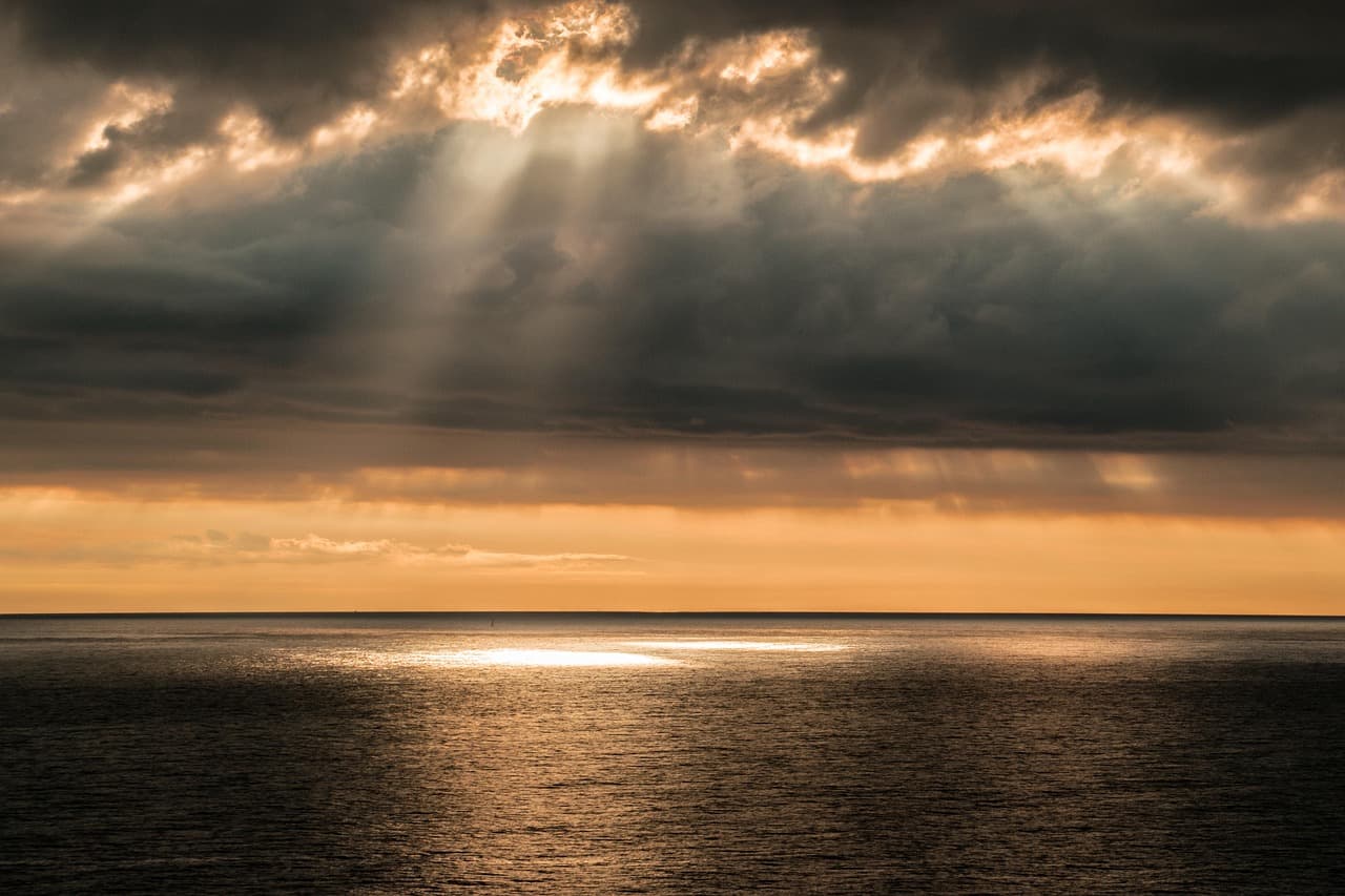Puesta de sol sobre el mar con nubes, en el chat de Departamento de Paysandú