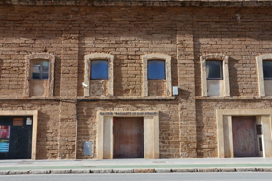 Calle empedrada con edificios históricos y catedral al fondo, en la sala de chat de Xàtiva