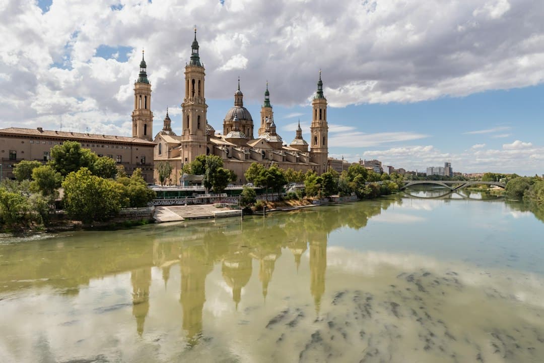Gran edificio con torres y un puente sobre el agua, en el chat de Calatayud