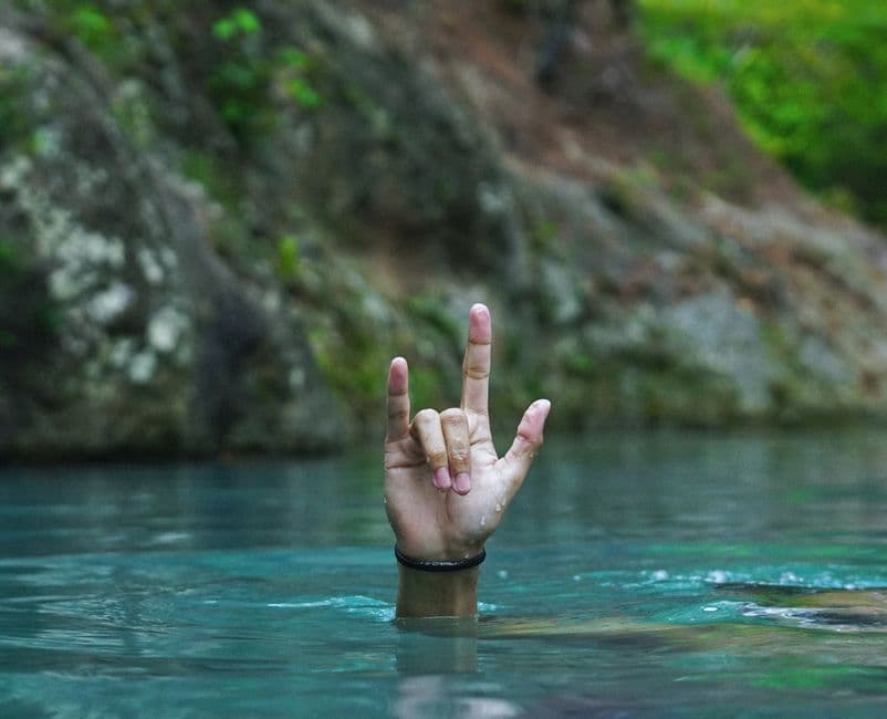 Persona bajo el agua haciendo un gesto con la mano, en el chat de Departamento de El Paraíso