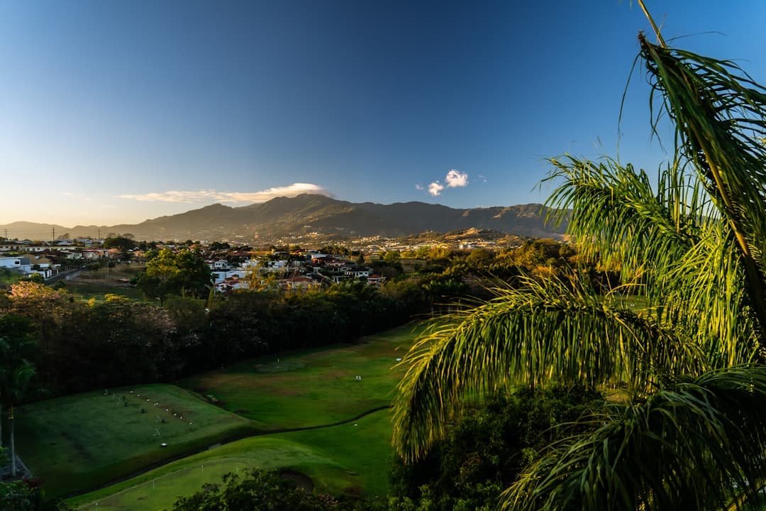 Hierba verde cerca de montañas verdes bajo cielo azul, en el chat de San José