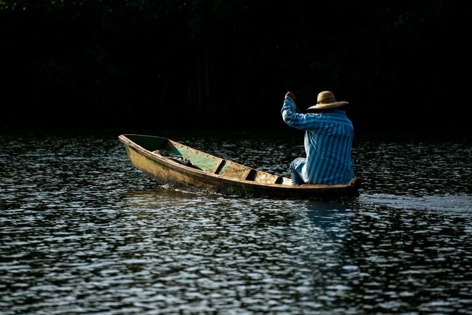 Hombre remando en una barca por un río, en el chat de Escuintla