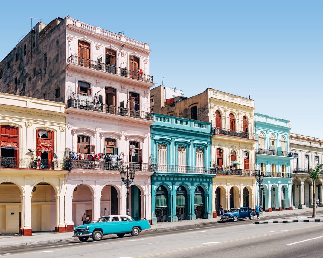 Dos automóviles estacionados frente a un edificio, en el chat de La Habana