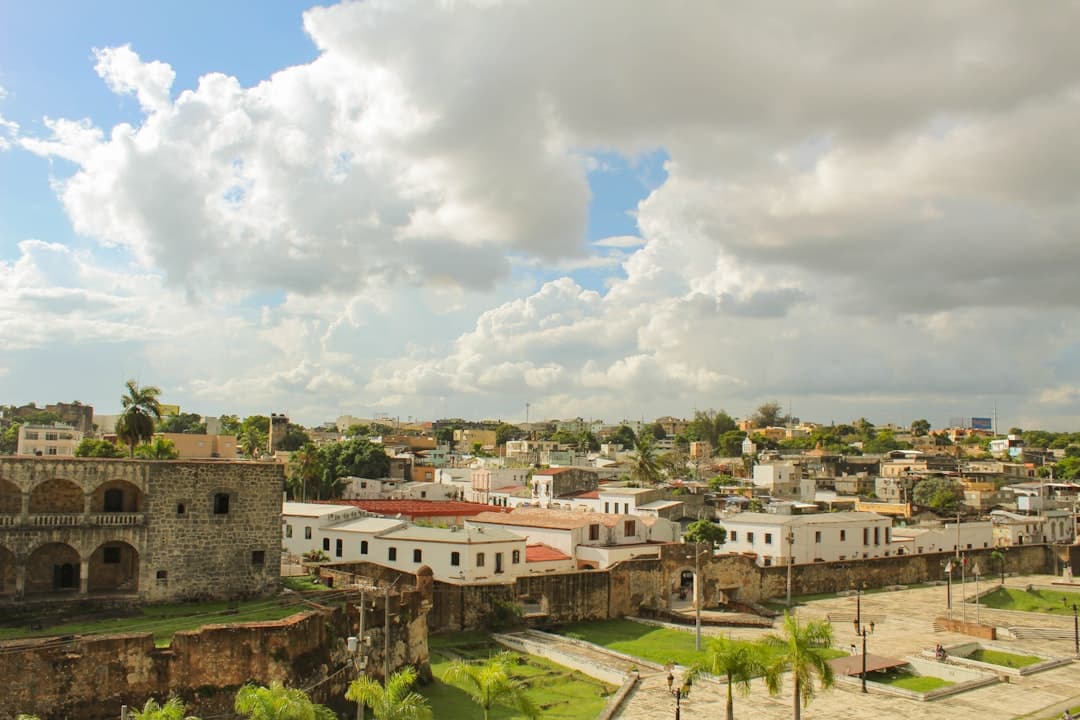 Edificios de hormigón blanco y marrón bajo nubes blancas, en el chat de Santo Domingo