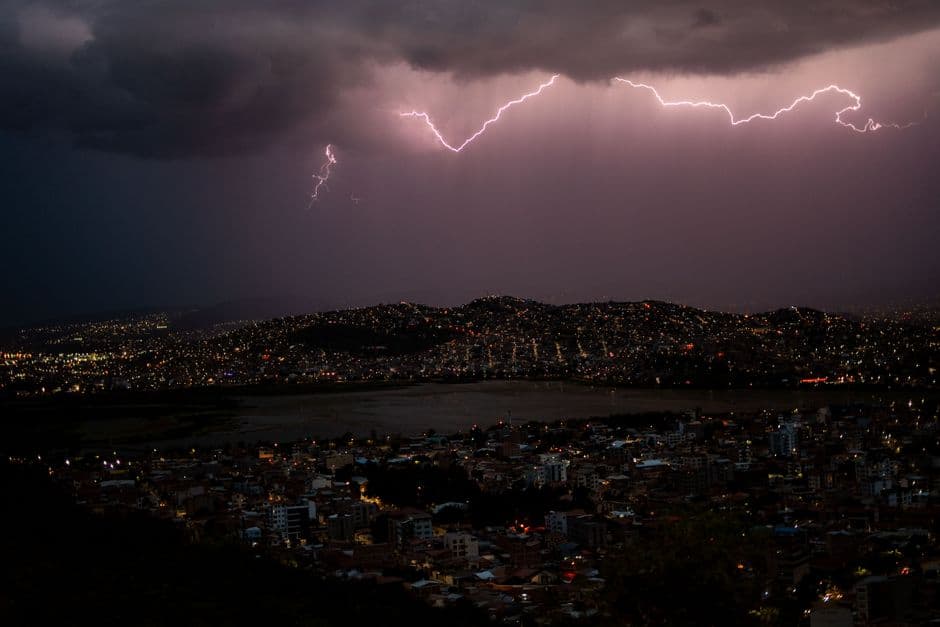 Tormenta eléctrica sobre una ciudad de noche, en el chat de Departamento de Cochabamba