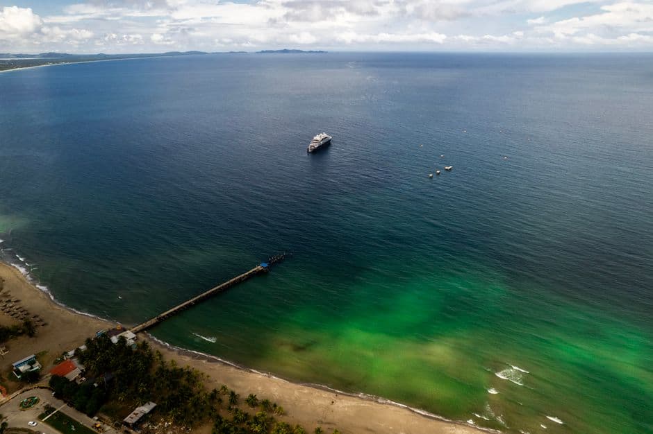 Playa con muelle y barco en la sala de chat de Puerto Cortés