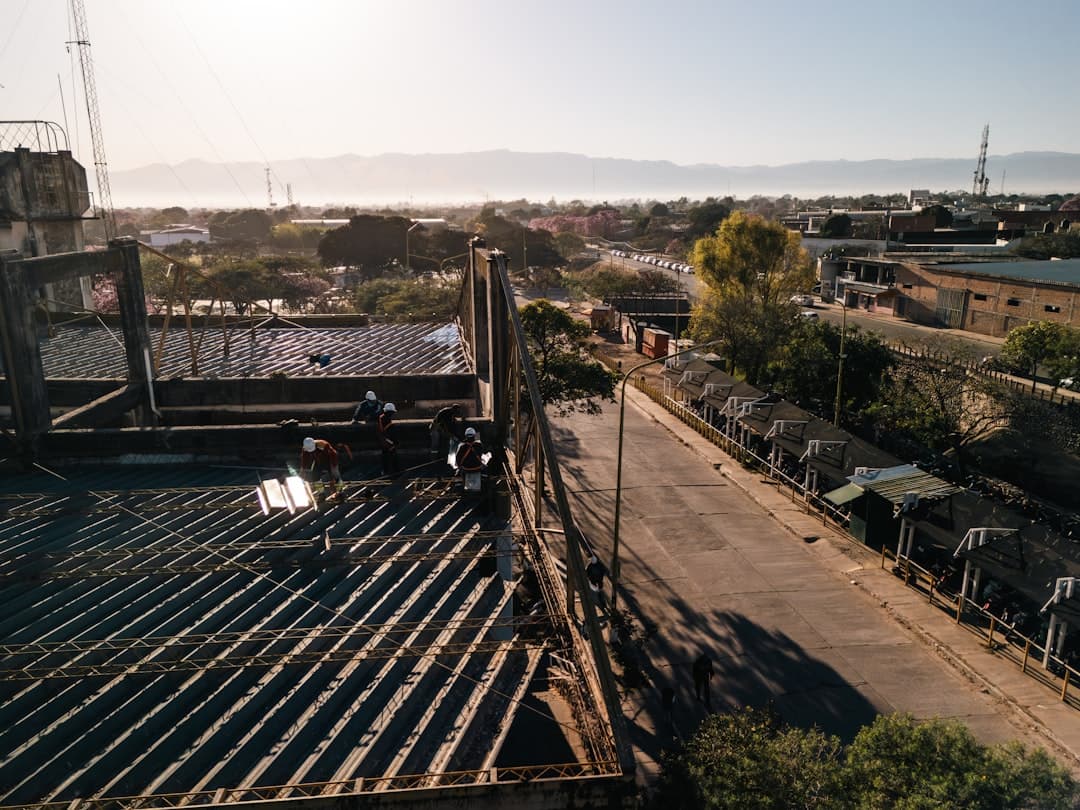 Trabajadores en azotea cerca de un puente al atardecer, en el chat de San Pedro de Jujuy