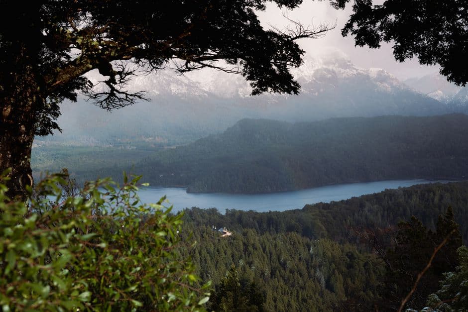 Lago de montaña rodeado de bosque de coníferas, en el chat de Bella Vista