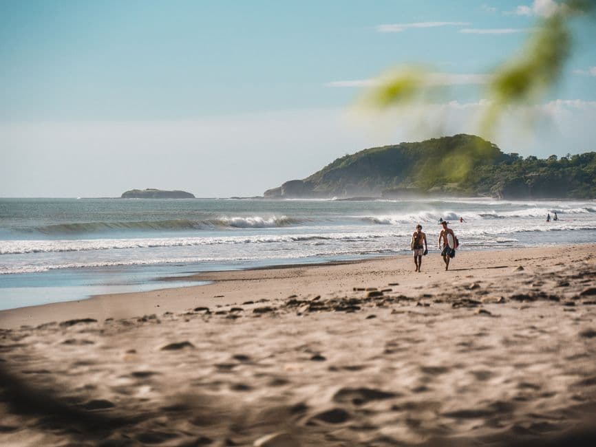 Pareja caminando por la orilla del mar en la sala de chat de San Juan del Sur