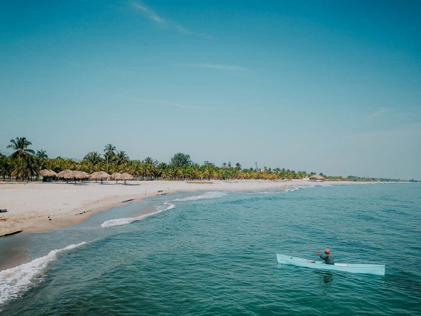 Persona en una tabla de surf en la playa, en el chat de Departamento de Lempira