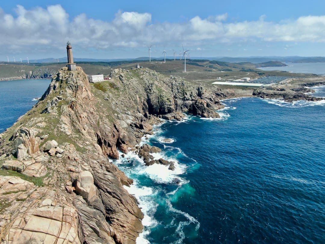 Acantilado rocoso con faro blanco sobre la costa, en la sala de chat de Camariñas