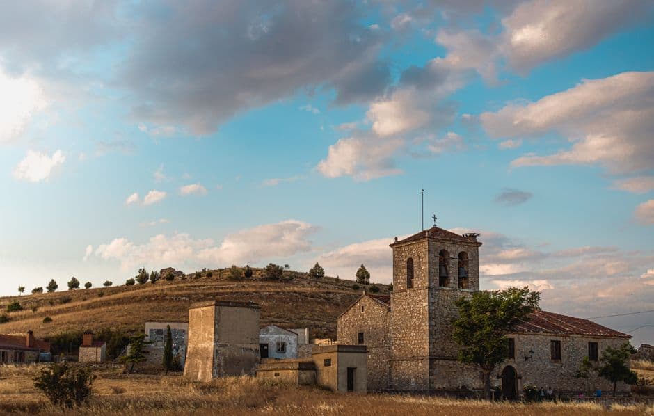 Castillo de piedra antiguo sobre colina con arbustos, en el chat de San José del Valle