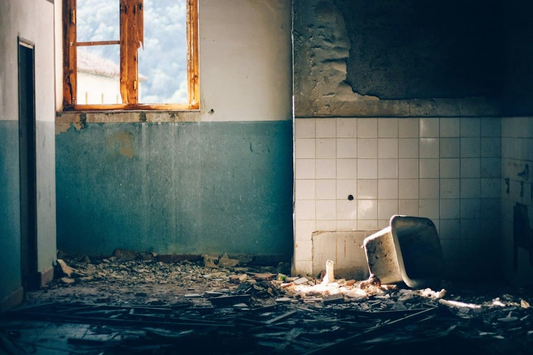 Lavabo destrozado, azulejos rotos y agua bajo luz natural, en la sala de chat de Hornachuelos