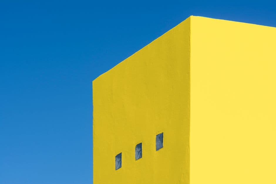 Edificio amarillo con tres ventanales bajo un cielo azul, en la sala de chat de Amarillo
