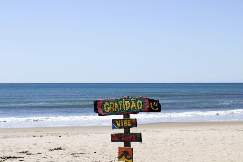 Cartel colorido en la arena junto al mar, en Brasil, en el chat de Magé