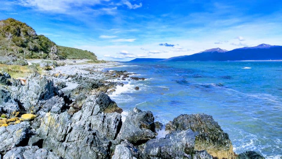 Rocas dispersas sobre arena mojada bajo cielo gris, en la sala de chat de Trenque Lauquen