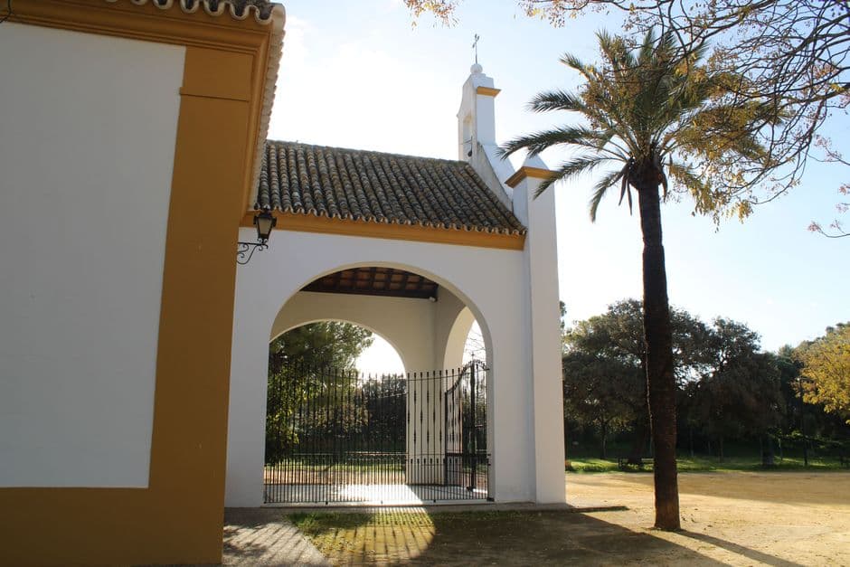 Entrada de iglesia con arco y puerta de madera, en el chat de El Carpio