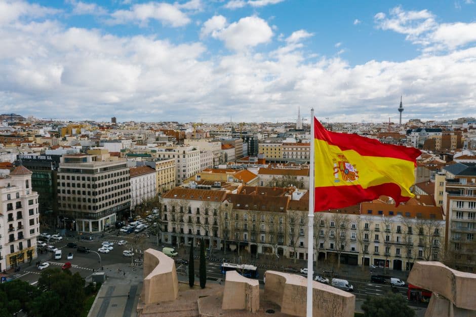 Bandera de España ondeando frente a una ciudad, en el chat de Zas