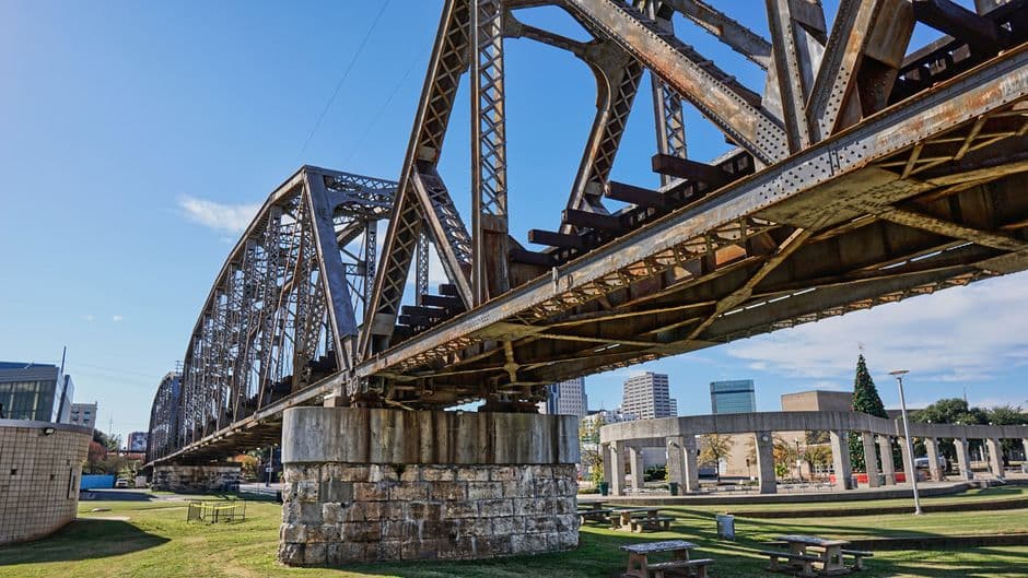 Puente metálico que cruza un parque con árboles y senderos, en el chat de Shreveport