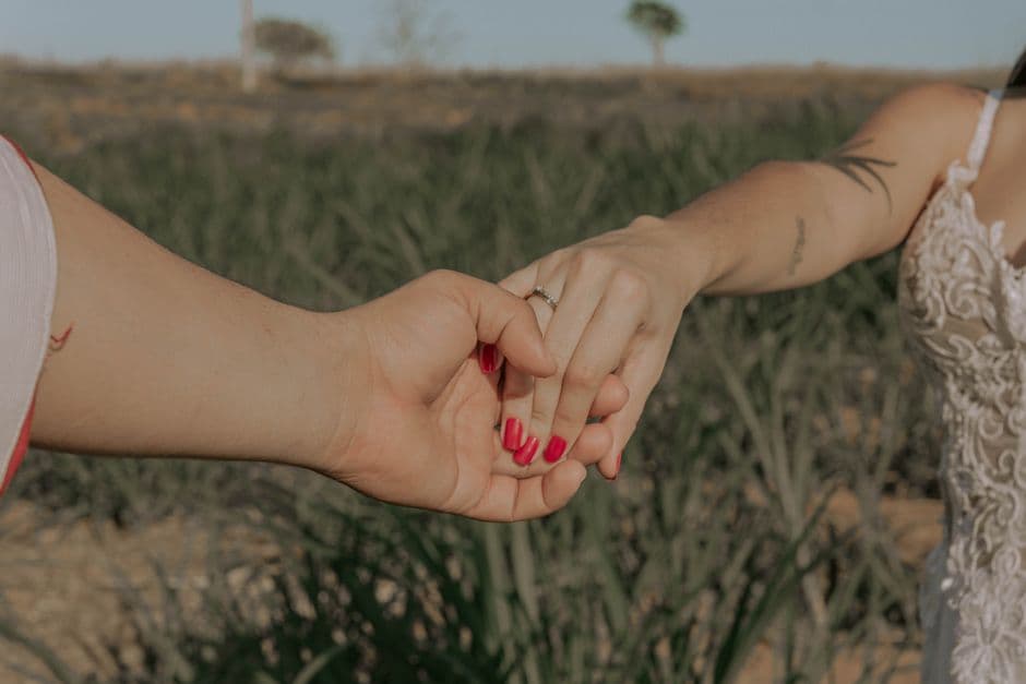 Manos de pareja comprometida con anillo bajo luz natural, en el chat de Presidente Prudente