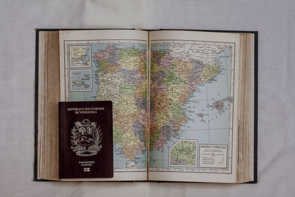 Un pasaporte sobre un libro con un mapa de España, en la sala de chat de Maturín
