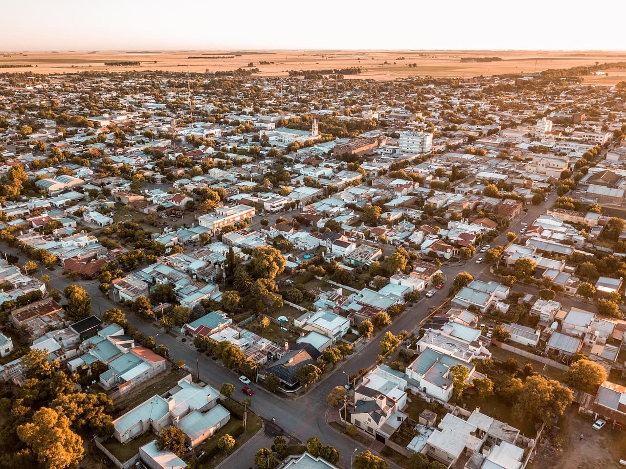 Vista aérea de la ciudad con casas y gente caminando, en el chat de Coronel Suárez
