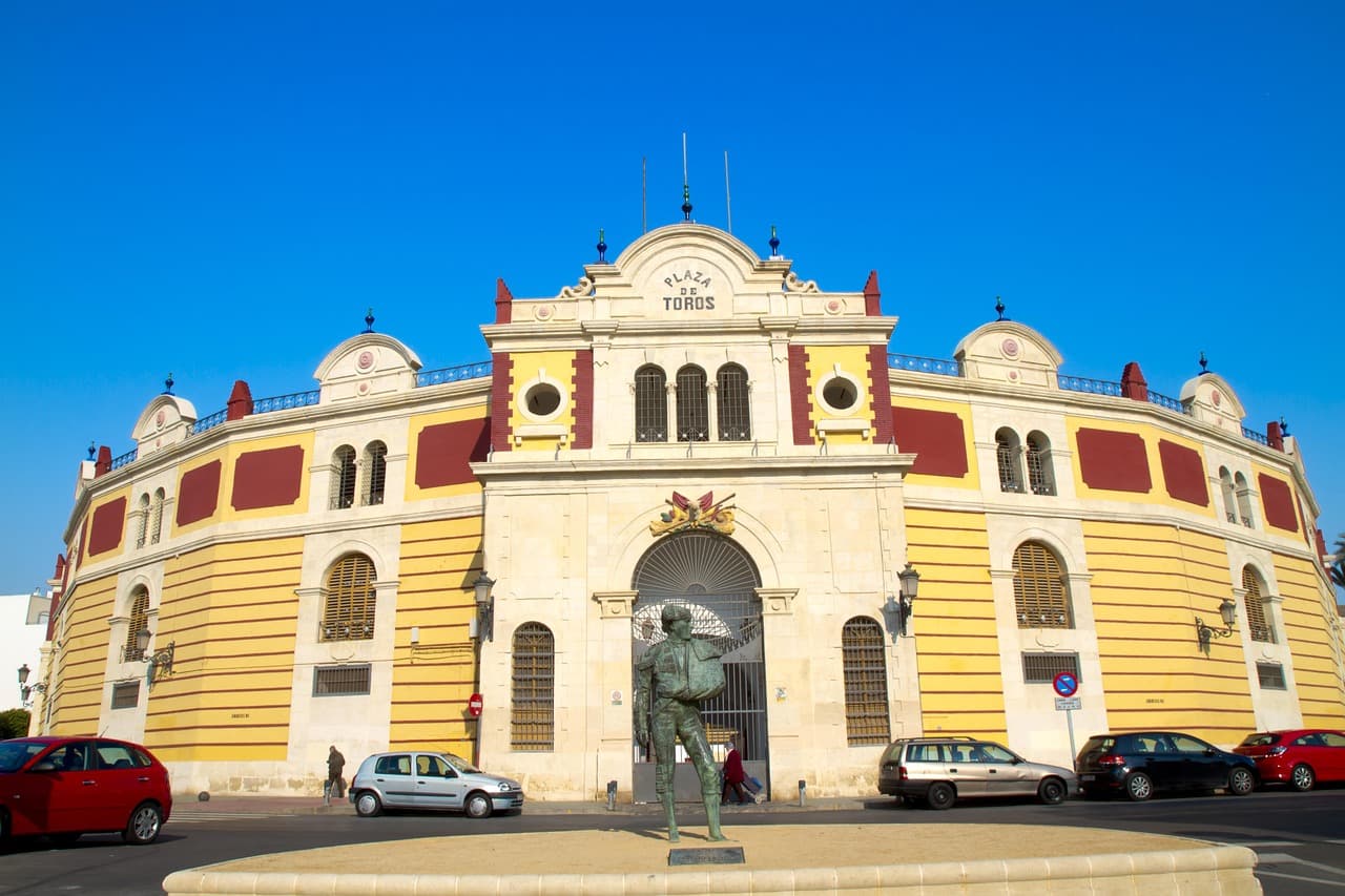 Plaza con torres y edificios de estilo andaluz, rodeada de palmeras, en el chat de Vilches