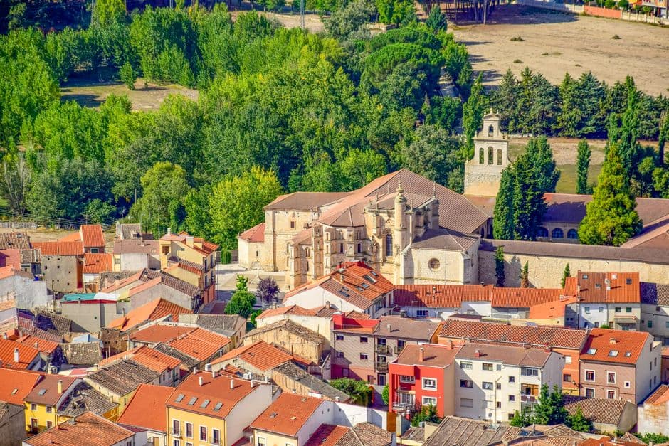 Monasterio de piedra con torres entre edificios urbanos, en la sala de chat de Santa Susanna