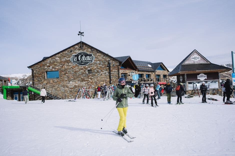 Esquiadores descienden nieve bajo cielo nublado, en la sala de chat de Cabana de Bergantiños