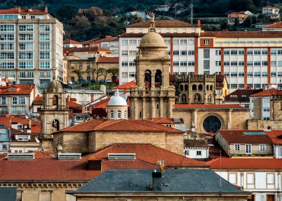 Callejón con edificios altos y iglesia de piedra, en la sala de chat de Ourense