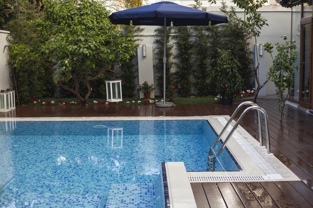 Casa de piscina con agua azul y zona de descanso, en el chat de Villa Udaondo