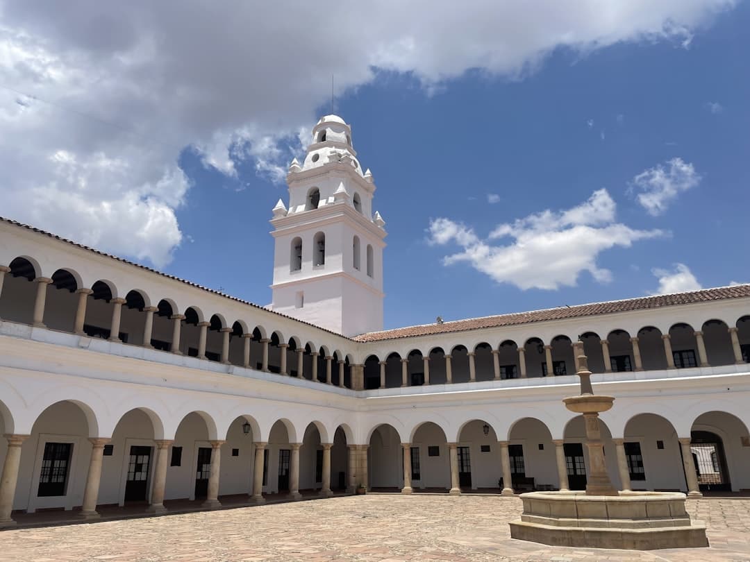 Un patio con torre del reloj al fondo, en la sala de chat de Sucre