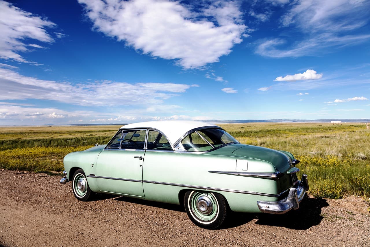 Coche antiguo de estilo cromado estacionado bajo el sol, en el chat de Corona