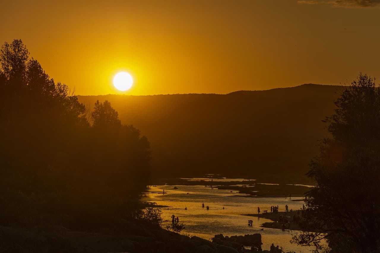 Cielo anaranjado con sol descendiendo sobre el horizonte, en la sala de chat de Villa Allende