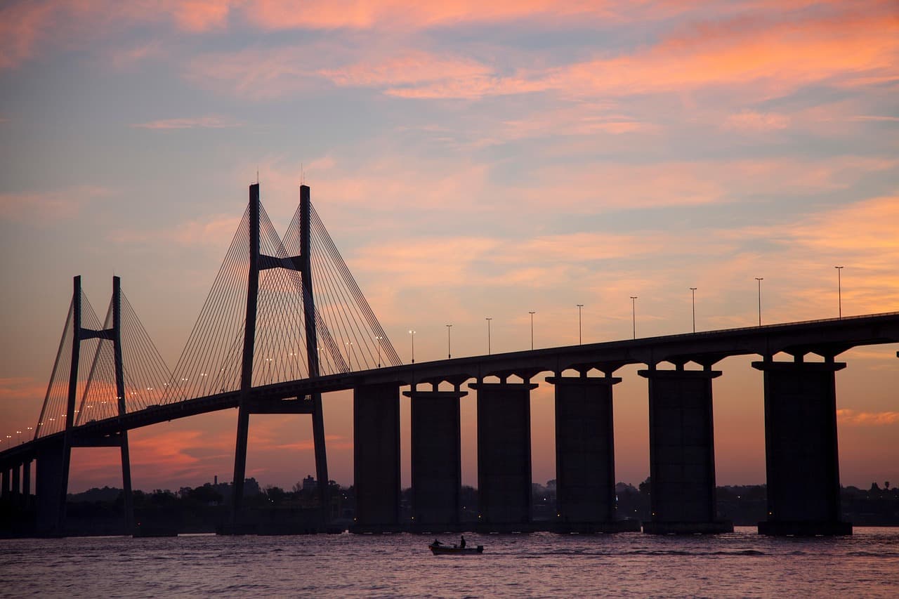 Puente de hierro sobre el Paraná con barandas iluminadas, en la sala de chat de Victoria