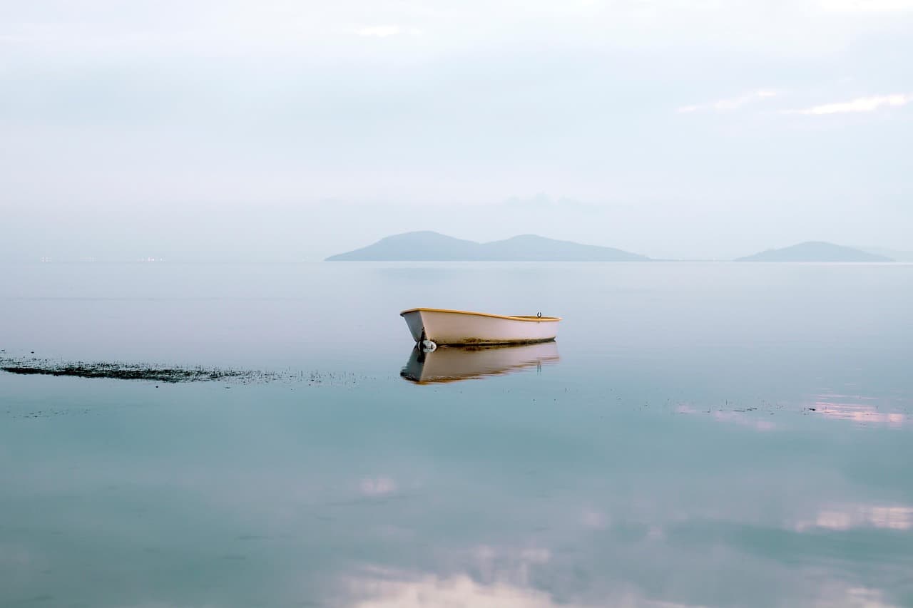 Barca en una laguna con reflejo en el agua, en el chat de Mar Chiquita