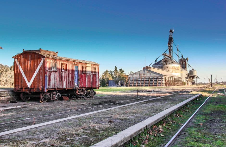 Vagón de tren de época junto a un silo, en el chat de Cañada de Gómez