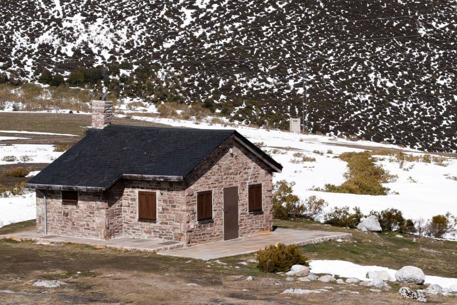 Casa de campo cubierta de nieve bajo un cielo gris, en el chat de Friol
