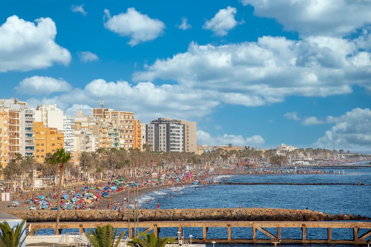 Playa de arena dorada y mar turquesa bajo cielo azul, en el chat de Cantoria