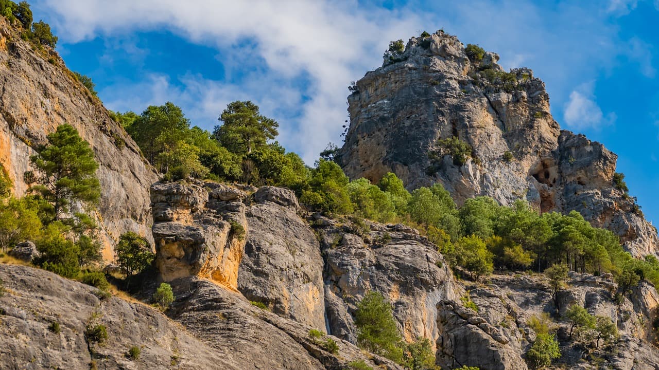 Bosques y rocas escarpadas bajo montañas, en la sala de chat de Arjonilla