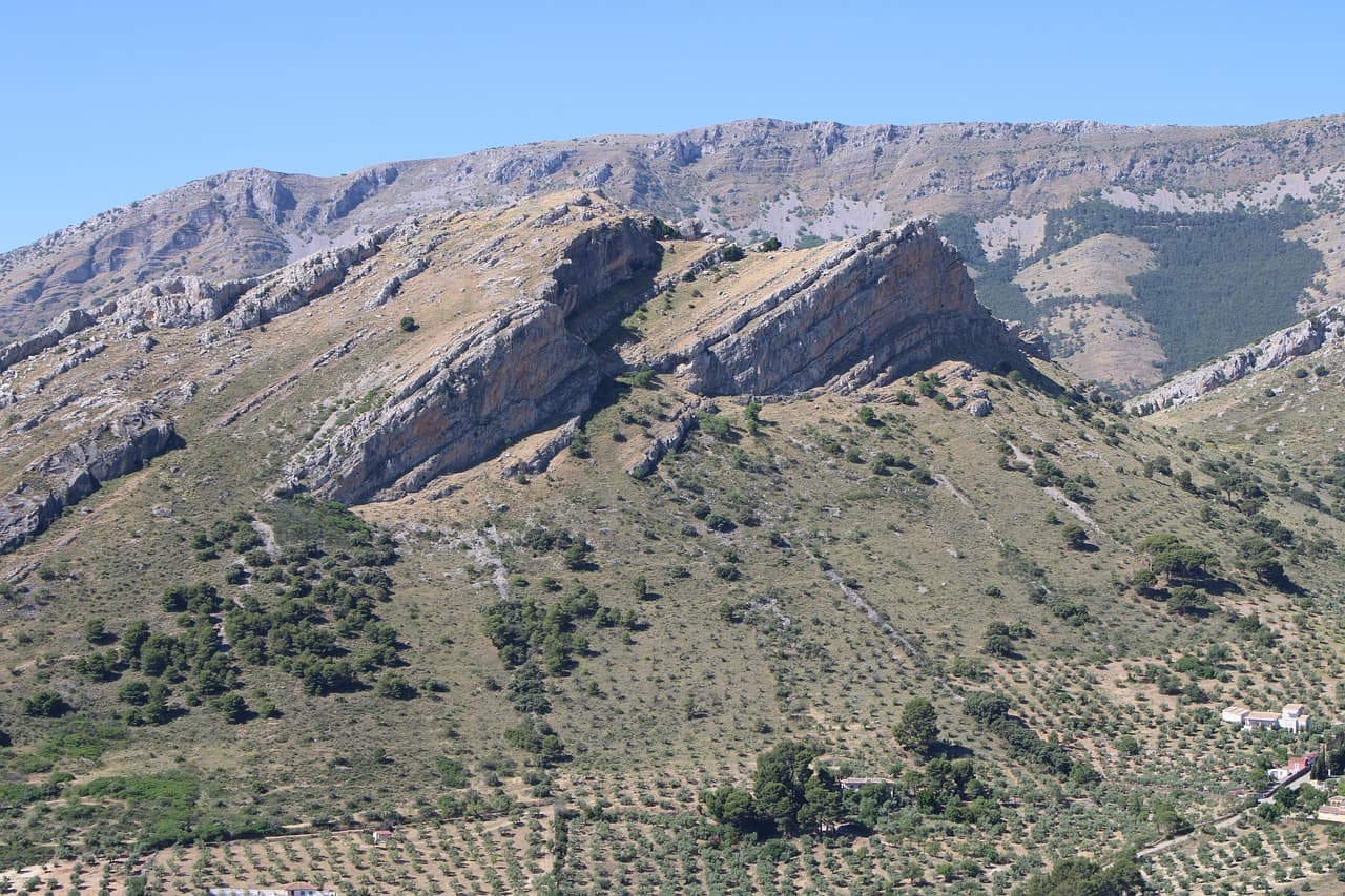 Montañas ondulantes con olivares y cielo azul sobre Jaén, en la sala de chat de Lopera
