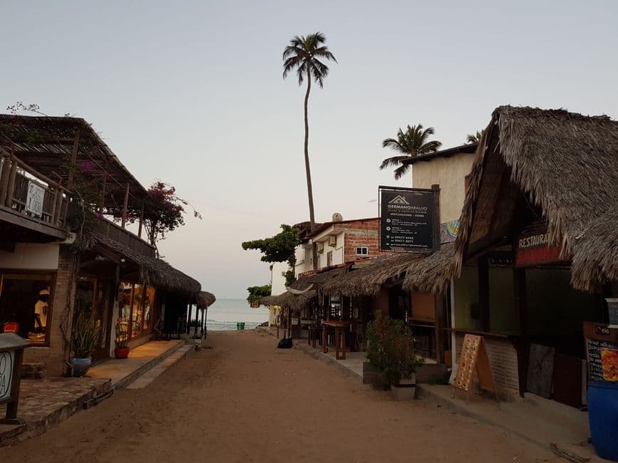 Calle empedrada iluminada por faroles al atardecer, en la sala de chat de Vila Curuçá