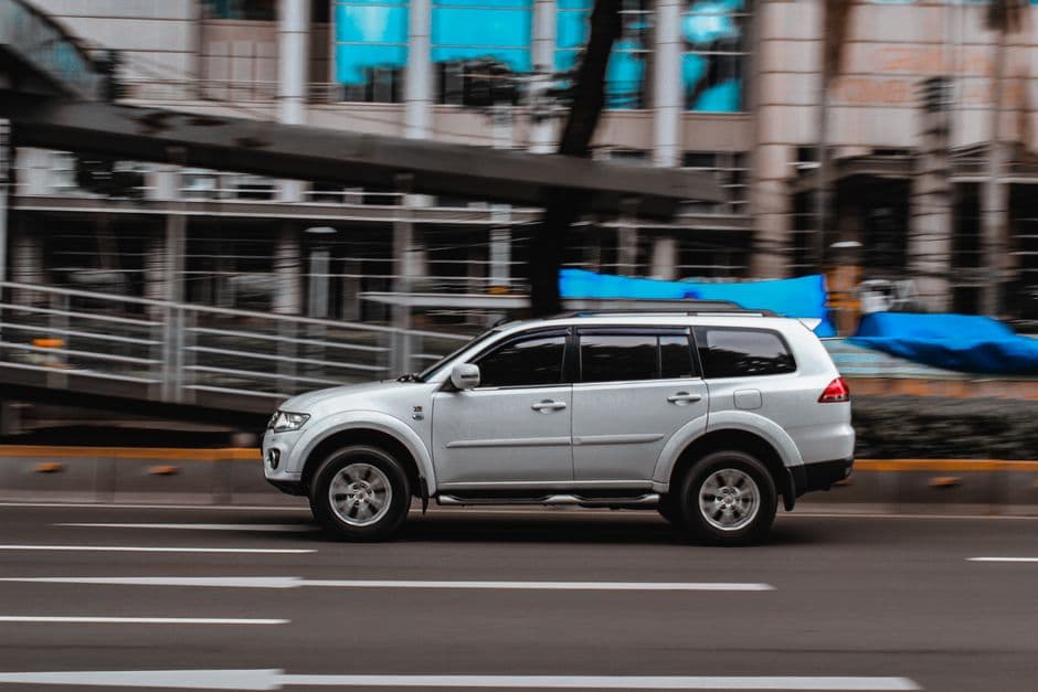 SUV blanco de perfil aparcado entre edificios urbanos, en la sala de chat de Monteros