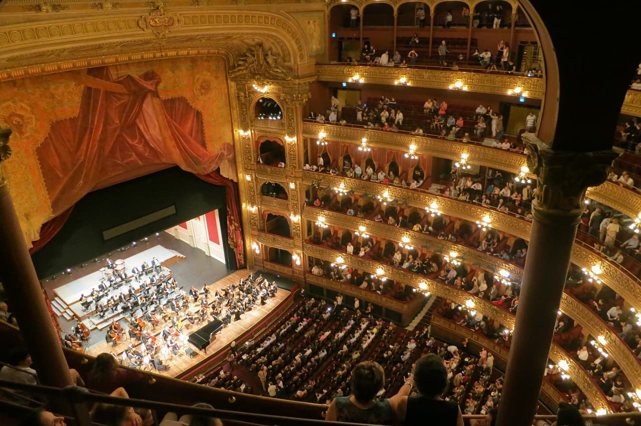 Orquesta de ópera en concierto con director y músicos, en la sala de chat de Colón