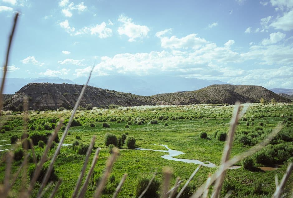Valle verde con montañas al fondo bajo cielo azul, en la sala de chat de Machagai
