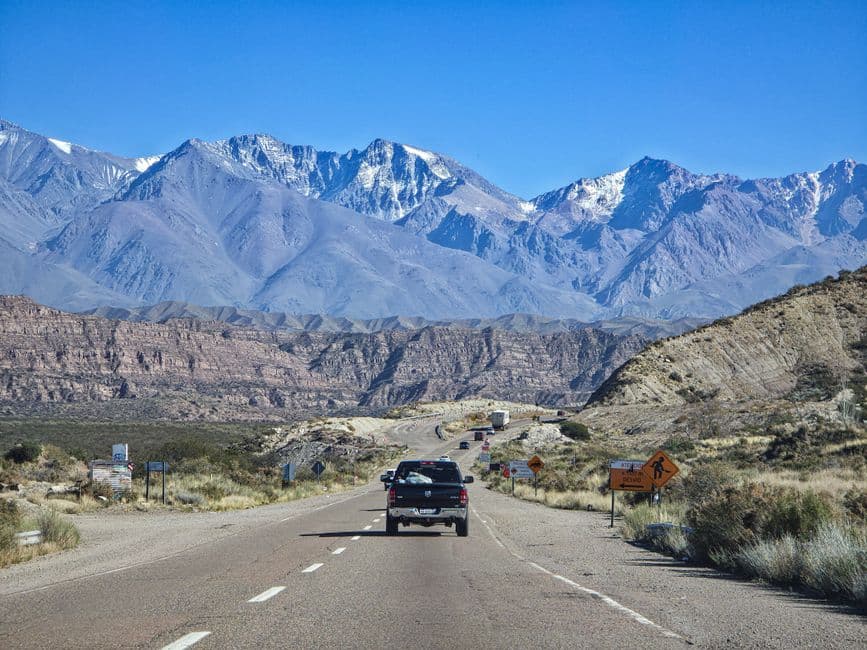 Carretera serpenteante entre montañas con picos nevados, en la sala de chat de Pichanal
